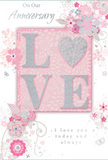 This tender anniversary card feels like a paper version of a romantic walk through Covent Garden at dusk, where soft light and shared memories seem to linger in the air. At its centre, the word LOVE is formed in soft, raised glitter, with the letter O replaced by a shimmering silver heart that stands slightly proud from the surface. The glitter is finely milled, giving off a delicate, pearly sparkle rather than a harsh shine, so that the letters and heart appear almost velvety to the touch. They sit on a gentle wash of blush pink, a background that glows like the sky over nearby Drury Lane after a summer shower. Around this focal motif, a constellation of delicate, stylised flowers and curling vines unfolds, painted in pastel pinks, muted mauves, and pale silvery greys. The petals have a soft, watercolour look, fading at the edges as if brushed once with clear water, while darker outlines provide detail like the fine stems and curls a florist sketches when planning an anniversary bouquet for local delivery. Tiny butterflies and petal-like swirls add a sense of movement, suggesting a light breeze sweeping through the flower stalls of Covent Garden. The phrases On Our Anniversary and I love you today and always appear in an elegant, slightly flowing script, unobtrusive yet full of feeling, like quiet words shared over coffee on a Sunday morning. The overall mood is intimate and gently celebratory, combining tenderness, subtle sparkle, and floral grace in a way that makes this card feel like a keepsake, perfect for marking a shared journey of love in the heart of London.